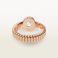 A gold 18k rose gold ring facing the back, featuring a textured band and bezel-set white diamond center stone. 