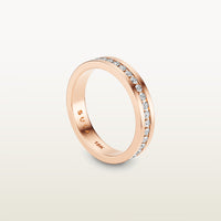 An 18k rose gold eternity band featuring round brilliant diamonds in a sleek channel setting, engraved with “SULA 18K” on the inside.