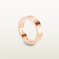A minimalist 18k rose gold band with a flat profile and 90 degree edge, engraved with “SULA 18K” on the inside.
