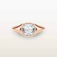 An 18k rose gold ring featuring a cushion-cut diamond in a soft bezel setting, with a smooth, tapered band.