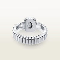 A gold 18k white gold ring facing the back, featuring a textured band and bezel-set white diamond center stone. 