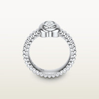 A gold 18k white gold ring featuring a textured band and bezel-set white diamond. 