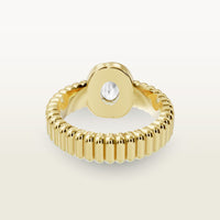 A gold 18k yellow gold ring facing the back, featuring a textured band and bezel-set white diamond center stone. 
