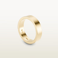 A minimalist 18k yellow gold band with a flat profile and 90 degree edge, engraved with “SULA 18K” on the inside.