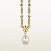 A delicate 18k yellow gold necklace  with elongated textured links, an ornate vintage-style bail, and a bezel-set pear-shaped diamond pendant.